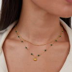 Niyah Bead Gold Chain Necklace, worn on a neck with two layered gold chains and green beads