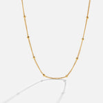 Niyah Bead Gold Chain Necklace, gold chain with small evenly spaced beads on white background