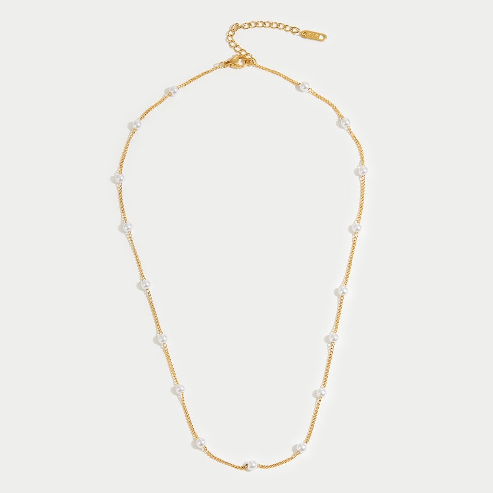 Nura Pearl 18K Gold Necklace, flat lay of a gold chain necklace with evenly spaced white pearls