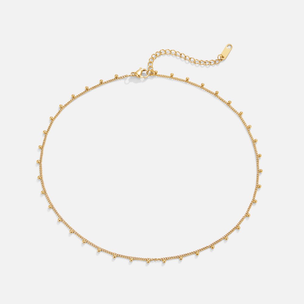 Nylah Bead Necklace, laid flat on white, gold chain with small bead accents and extender