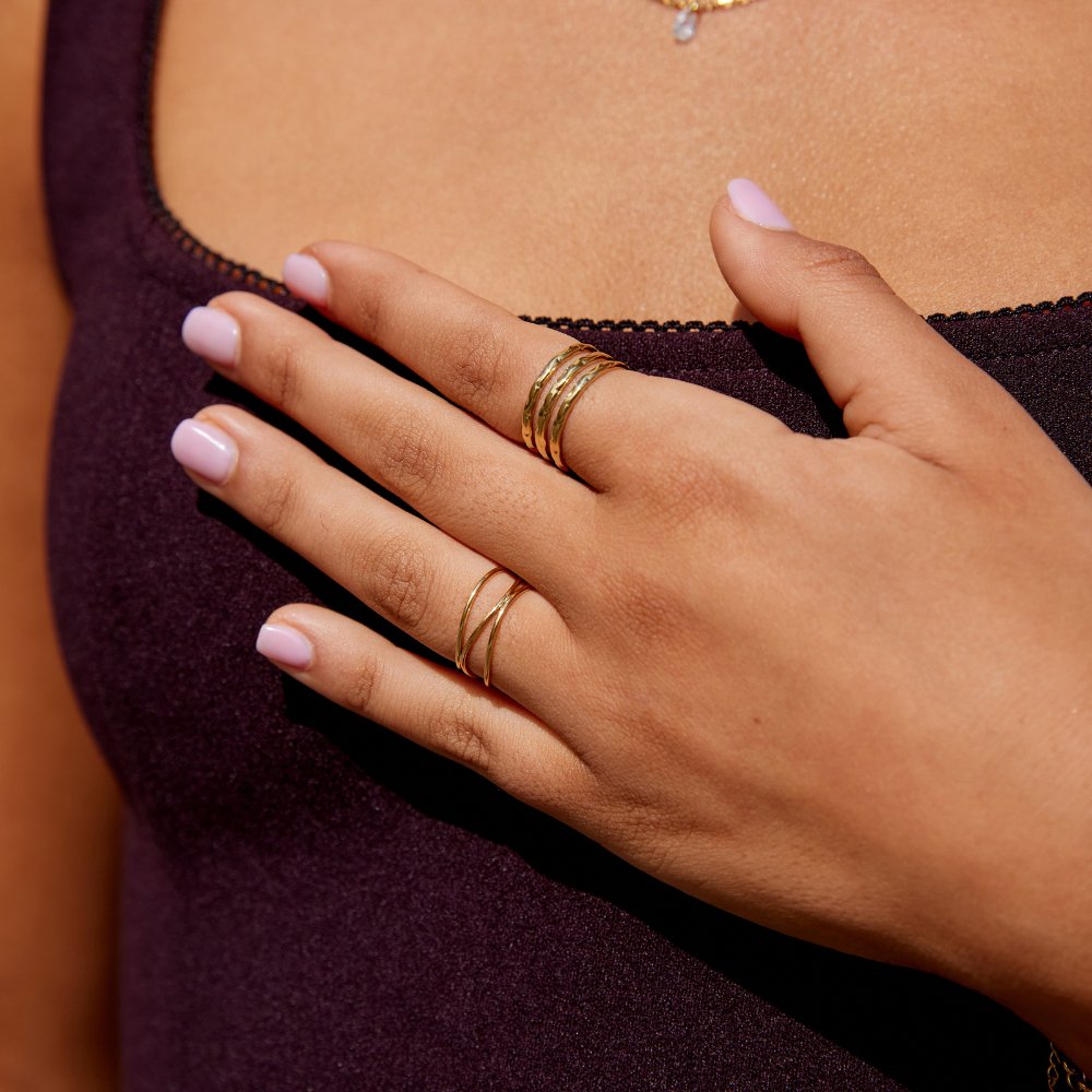 Ohio Layered Gold Ring, worn on a hand resting on a plum top, gold rings visible
