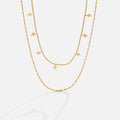 Phoenix Layered Necklace, two gold layered chains, one beaded with diamond-shaped charms, on white