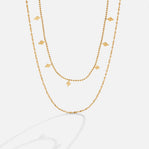 Phoenix Layered Necklace, two gold layered chains, one beaded with diamond-shaped charms, on white
