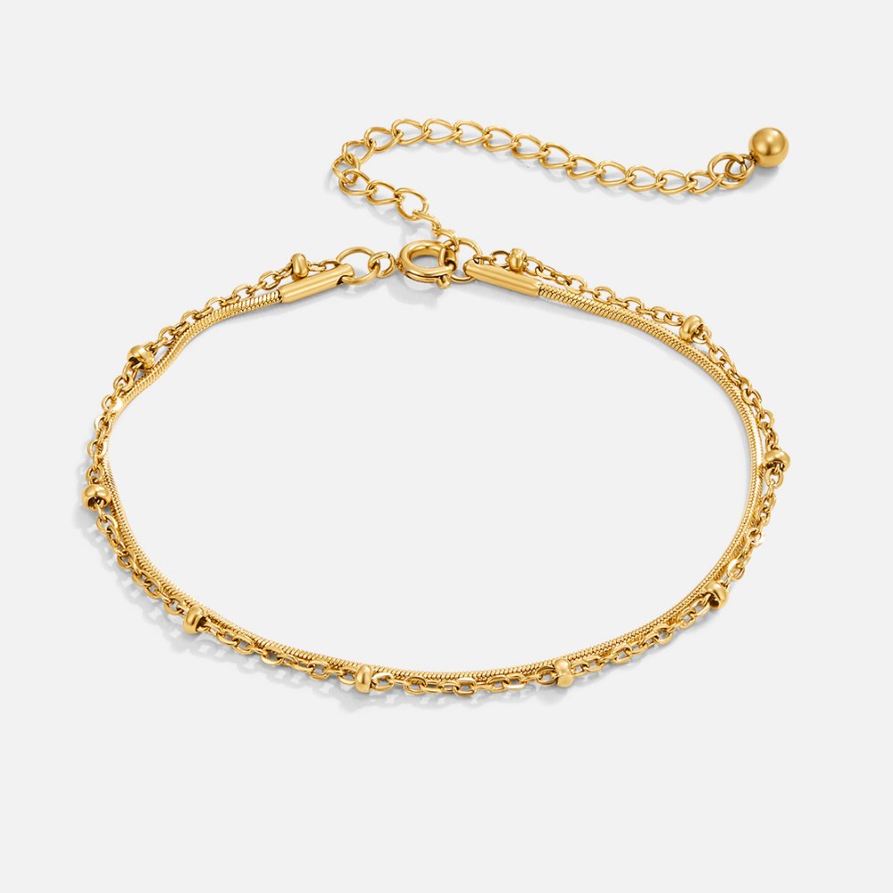 Pia Gold Layered Bracelet, flat lay of gold double-strand chain with bead accents and extender