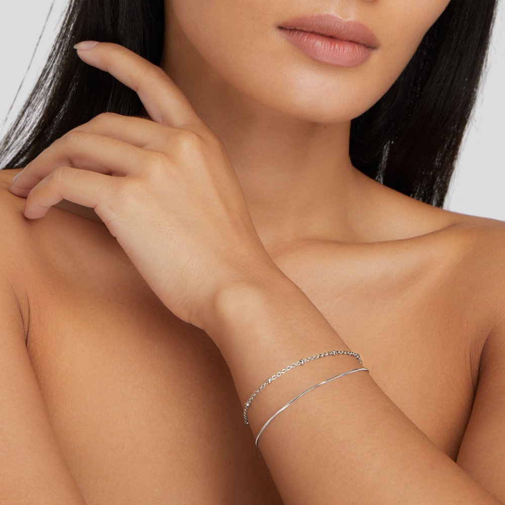 Pia Silver Layered Bracelet, worn on a wrist with a fine chain and a thin silver bangle