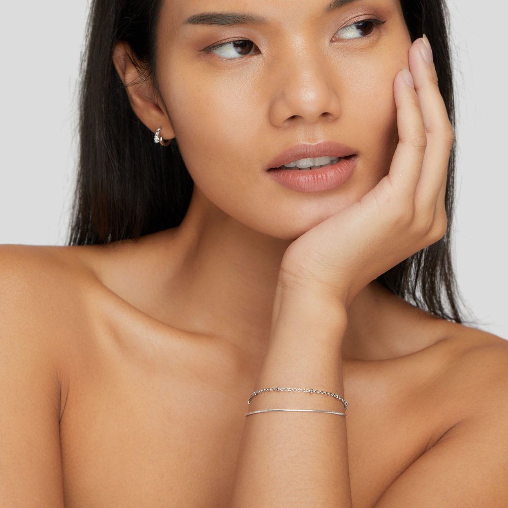 Pia Silver Layered Bracelet, worn on a wrist with a hand resting against a cheek