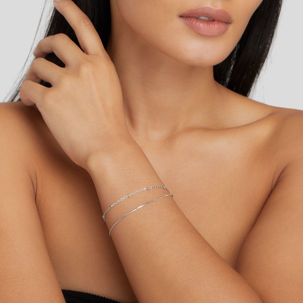 Pia Silver Layered Bracelet, worn on a wrist with a thin chain and a bangle