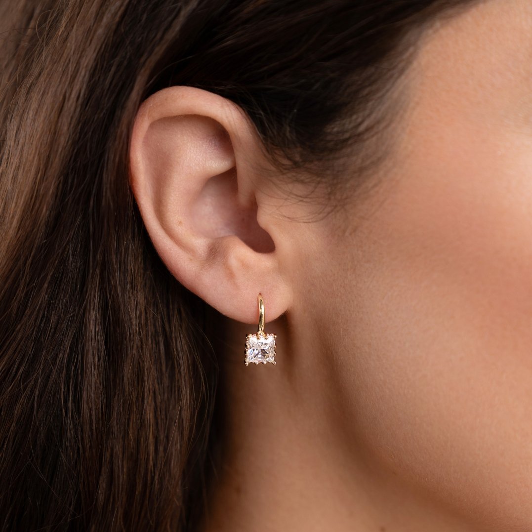 Piper Crystal Drop Earrings, worn on an ear, gold hoop with square clear crystal drop