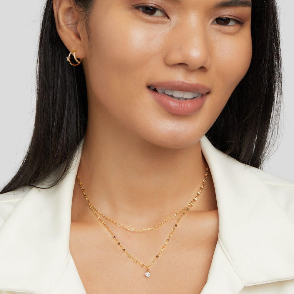 Piya Crystal Layered Necklace, worn on a model with a gold hoop earring and white jacket
