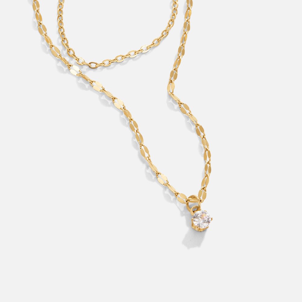 Piya Crystal Layered Necklace, two gold chains laid flat on white, with a round crystal pendant