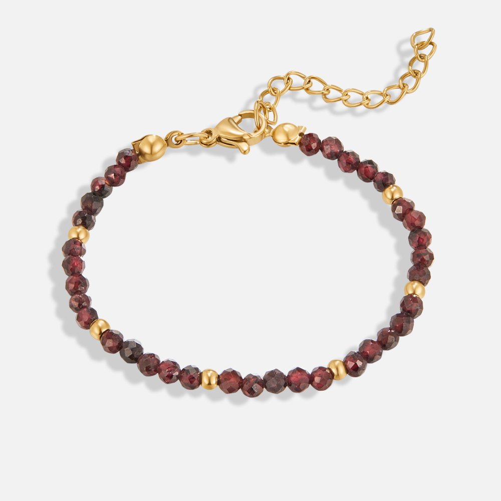 Red Garnet Bead Bracelet, laid flat on a light background, dark red faceted beads with gold spacers