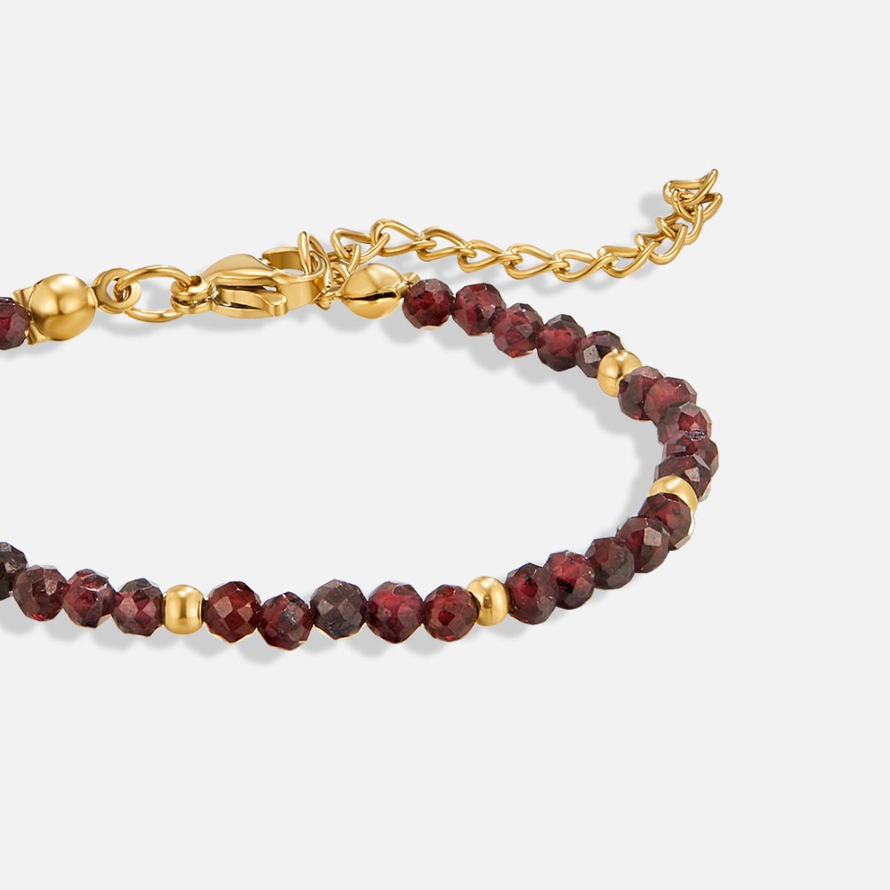 Red Garnet Bead Bracelet, close-up of faceted dark red beads with gold spacers and clasp on white