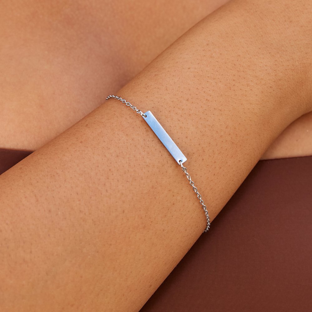 Rina Silver Bar Bracelet, worn on a bare forearm, thin silver chain with a flat bar
