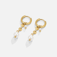 Rini Pearl Tassel Earrings, pair of gold hoop earrings with pearl drops, laid flat on white