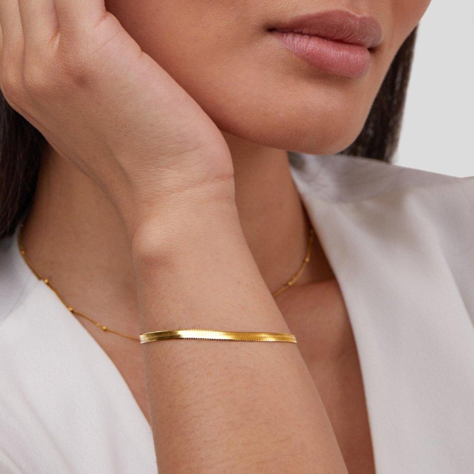 Sarya Snake Chain Gold Bracelet, worn on a wrist with a hand raised to the chin