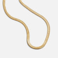 Sarya Snake Chain Gold Necklace, gold snake chain lying in a curving loop on white