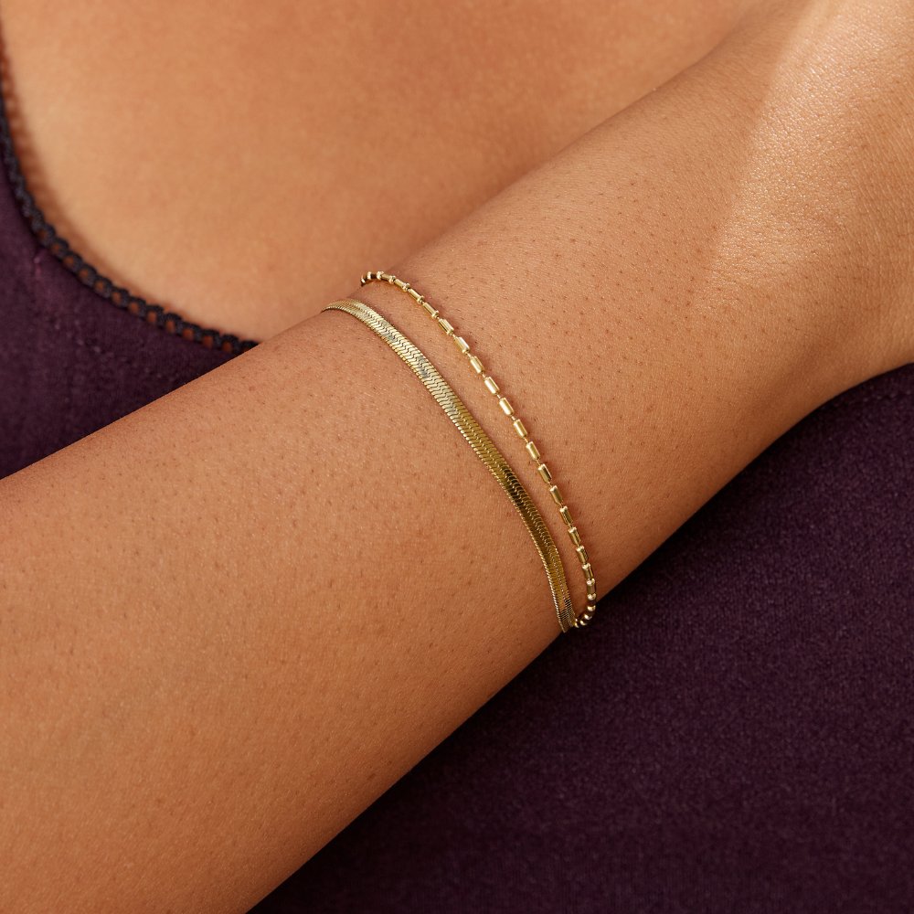 Selene Snake & Bead Chain Bracelet, worn on a wrist with two gold chain bracelets stacked
