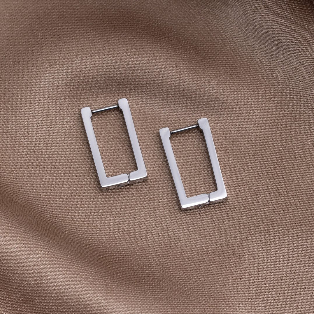 Silver Rectangle Hoop Earrings, two rectangular hoops lying flat on brown satin fabric