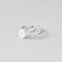Silver White Blossom Flower Ring, lying flat on grey, open band with white flower and leaf
