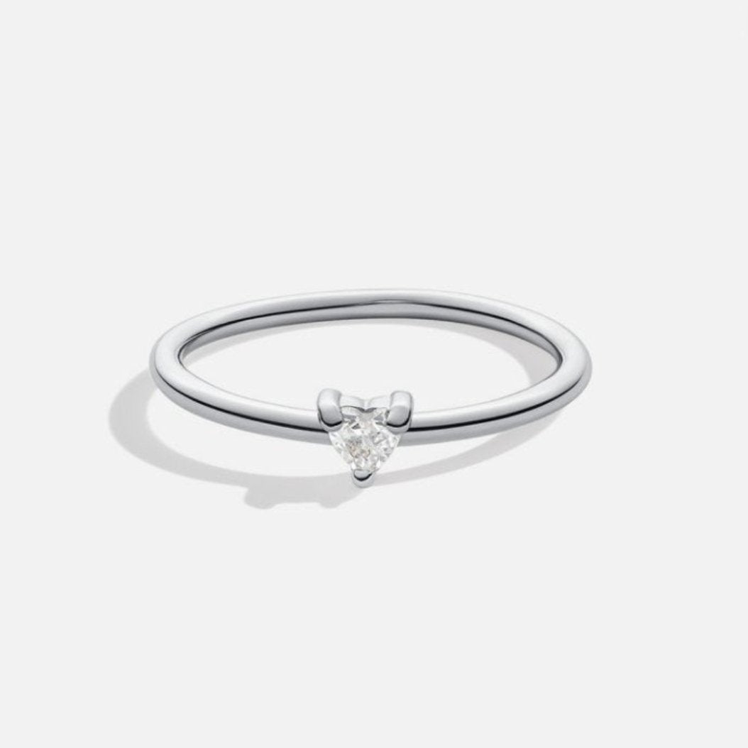 'Small Love' Crystal Heart Ring, standing alone on plain light background, thin silver band