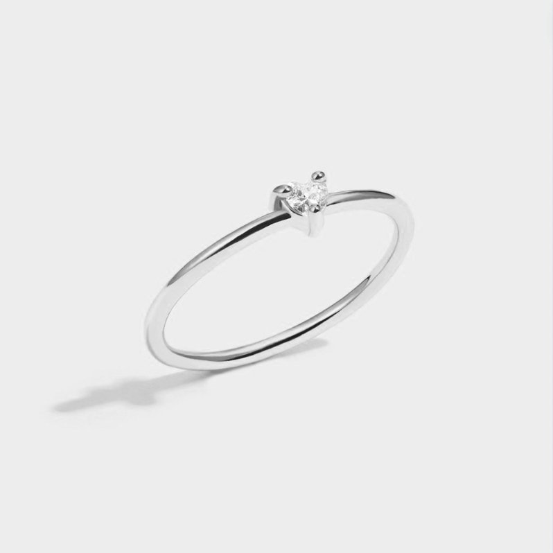 'Small Love' Crystal Heart Ring, thin silver band with a small heart-cut stone on a plain background