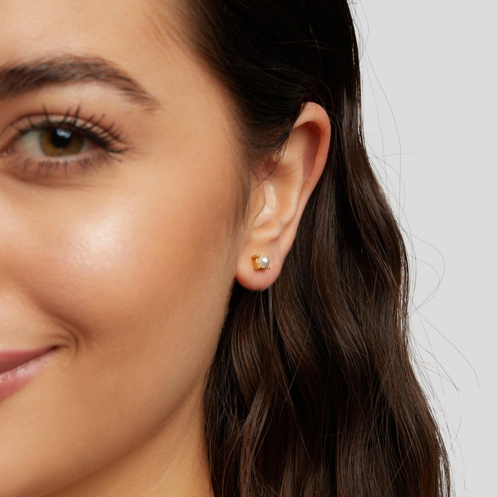 Free Sofia Pearl Stud Earrings, worn on an ear, small gold setting with a pale pearl