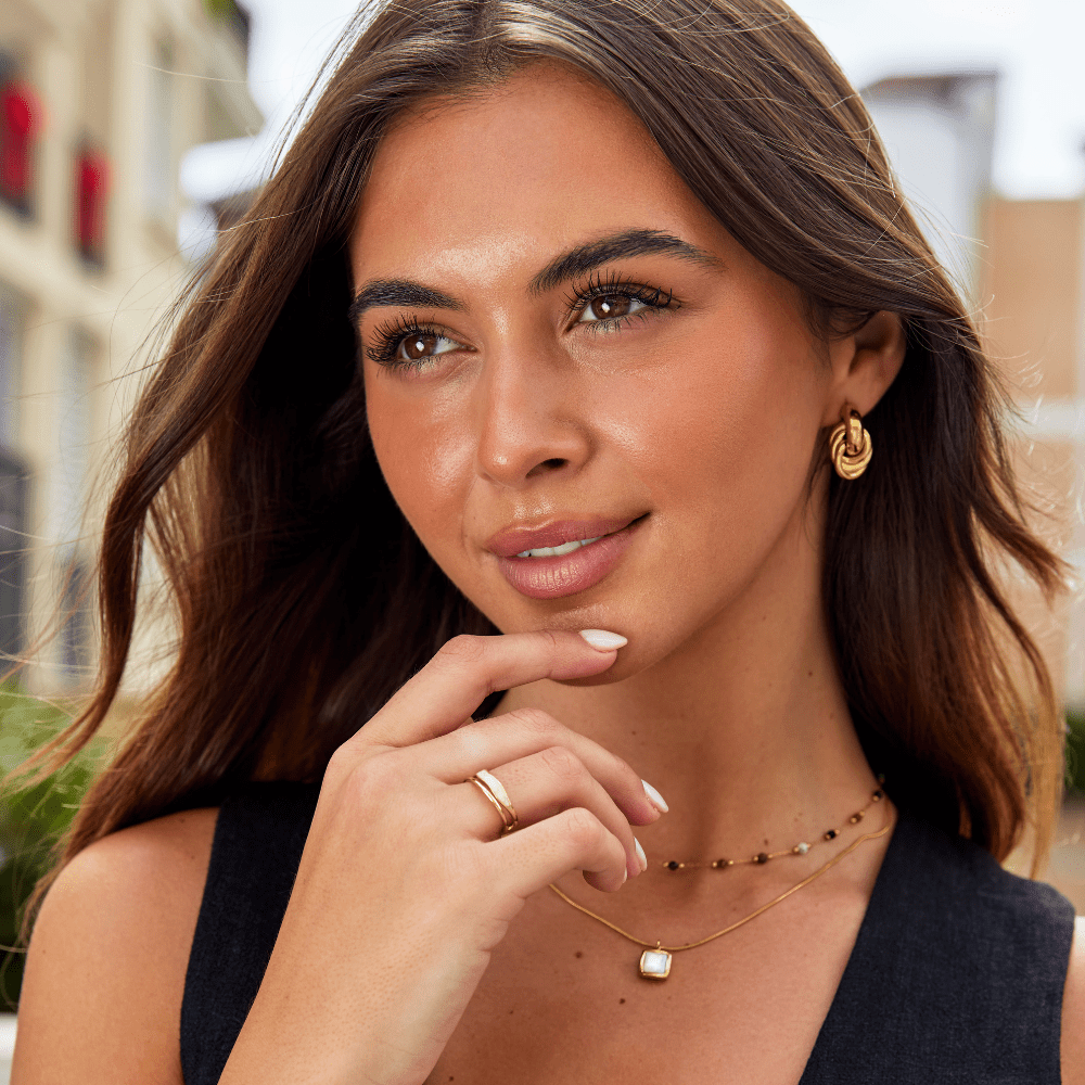 Sofia Twisted Silver Hoop Earrings, worn on a model, hand resting at her chin