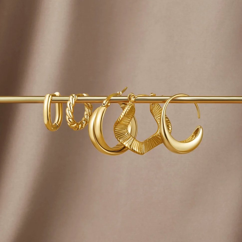 Talia Gold Hoop Earrings, five gold hoop earrings hung on a gold bar against a taupe satin backdrop