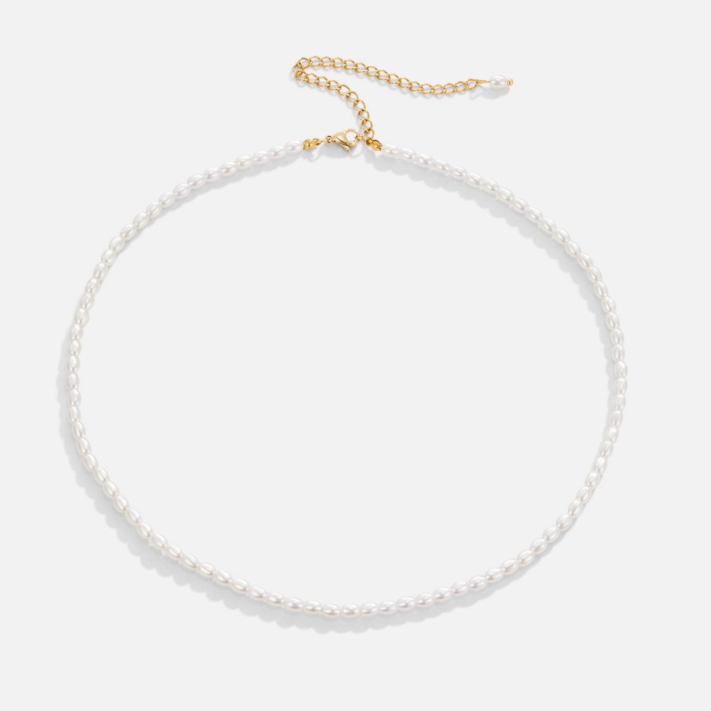 Temi Pearl Necklace, flat lay of small white rice pearls with gold clasp and extender chain