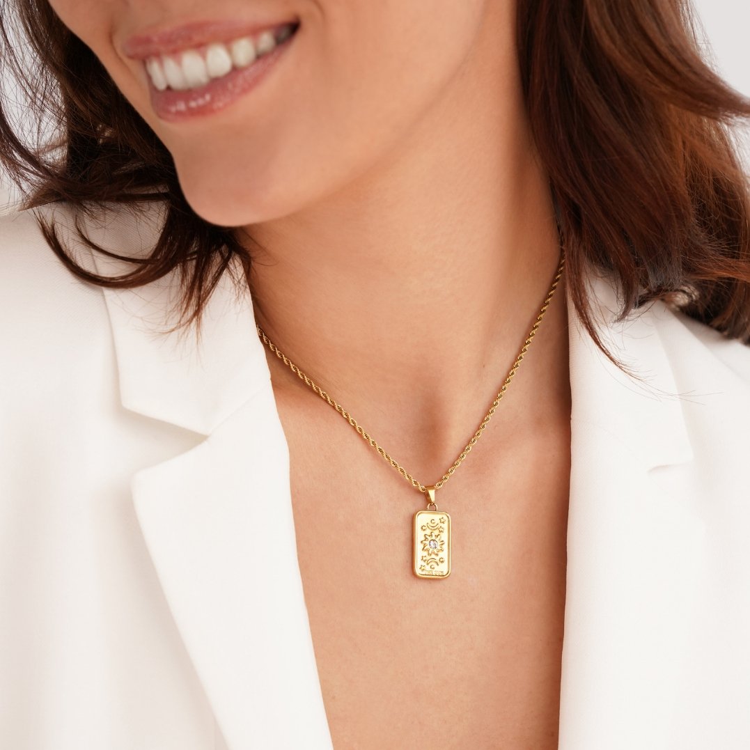 ‘The Sun’ Tarot Pendant Necklace, worn on a smiling woman in a white blazer, gold rope chain
