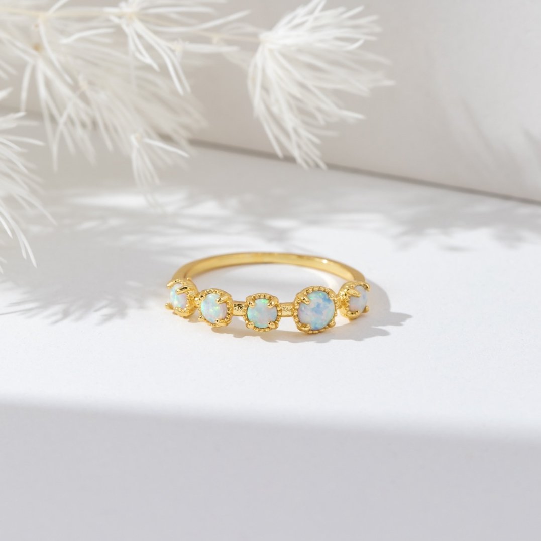 Tiffany Opal Stone Ring, gold band ring with five pale opal stones on white surface