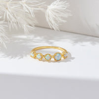 Tiffany Opal Stone Ring, gold band ring with five pale opal stones on white surface