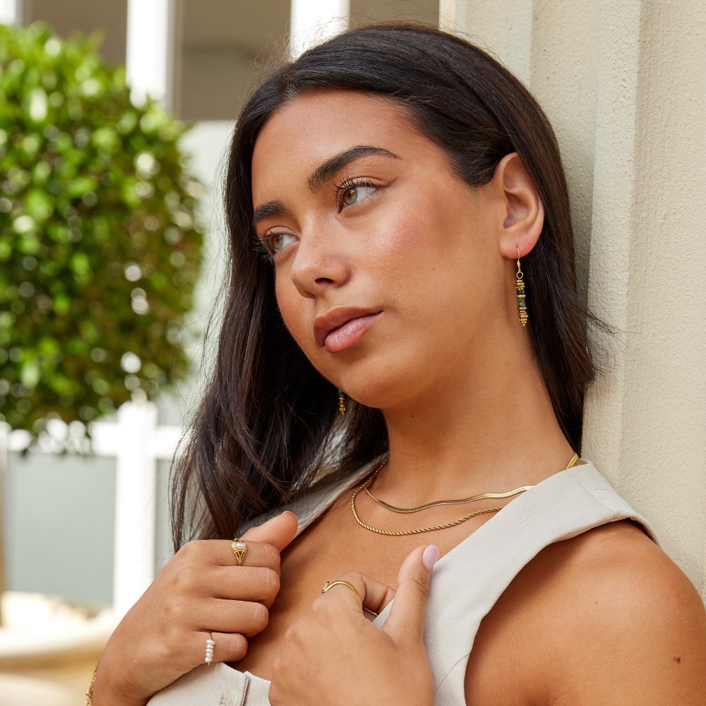 Turquoise Stone Drop Earrings, worn on a model with layered gold necklaces and rings
