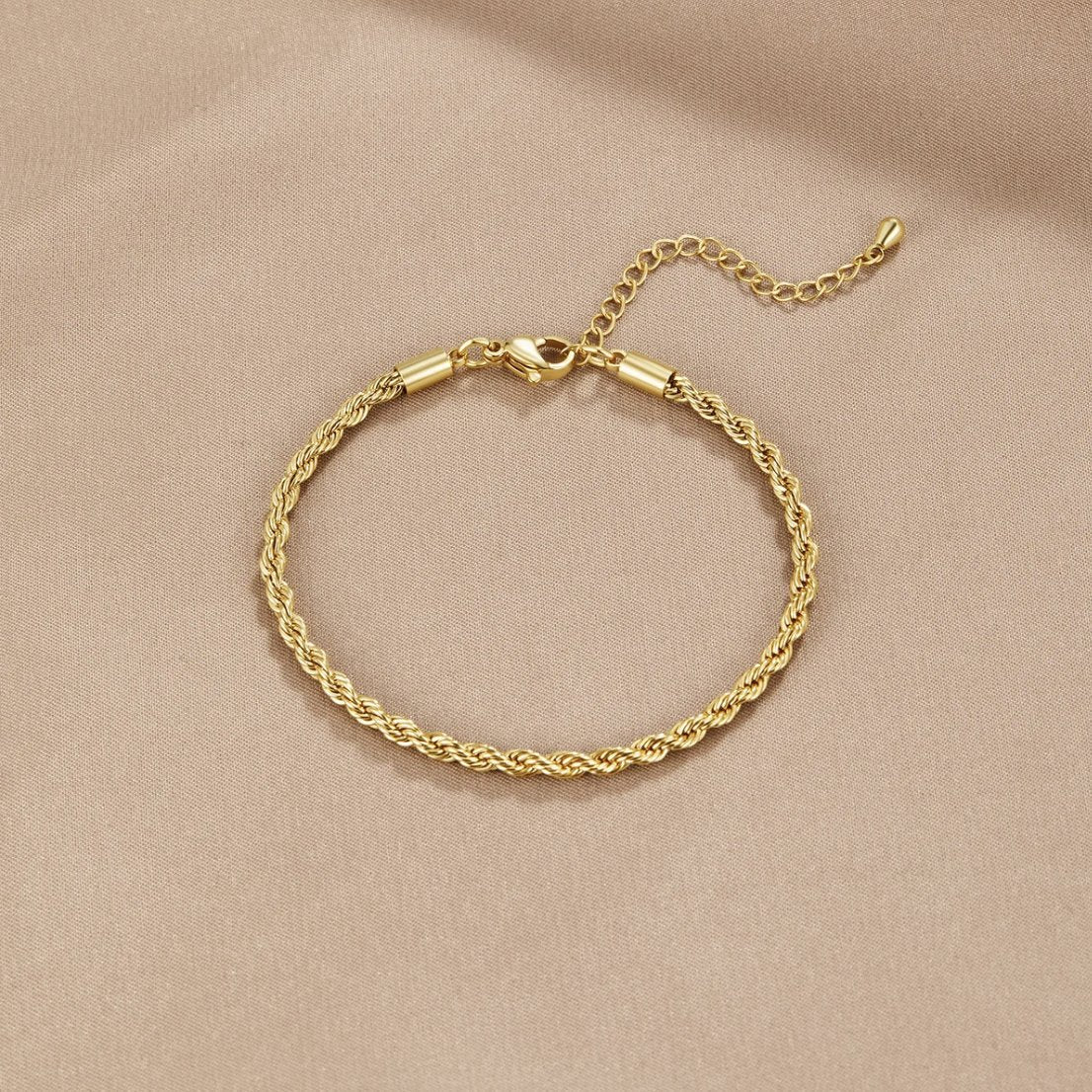 Twisted 18K Gold Bracelet, laid flat on beige satin, twisted gold chain with clasp and extender