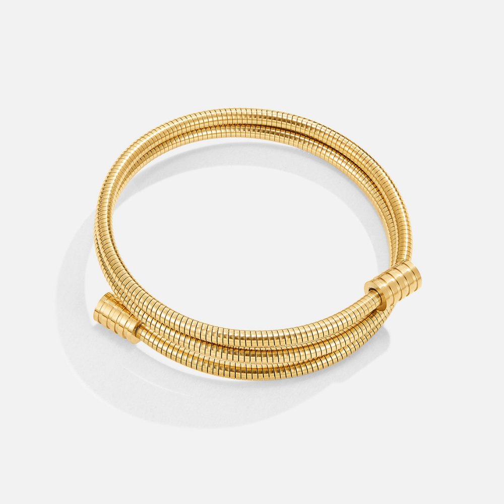 Twisted Gold Bracelet, flat-lay of a coiled gold snake-chain bracelet on white