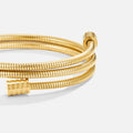 Twisted Gold Bracelet, close-up of a coiled gold bracelet with ribbed ends on white