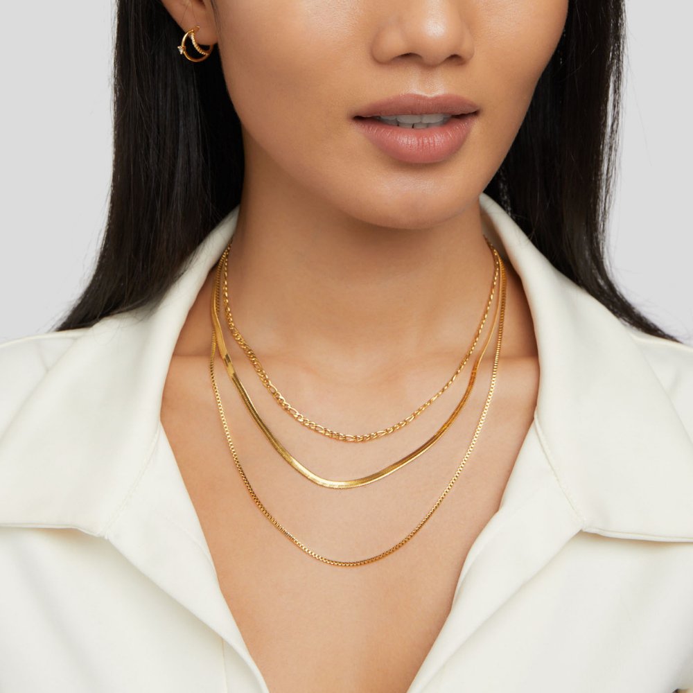 Vienna Layered Chain Necklace, worn on a model in a white collared top, three gold chains layered