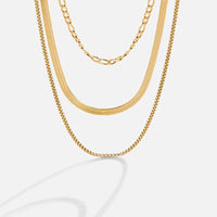 Vienna Layered Chain Necklace, three gold chains layered together against a pale background