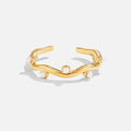 Wavey Pearl 18K Gold Ring, flat on white, open wavy band with small pearls set along it