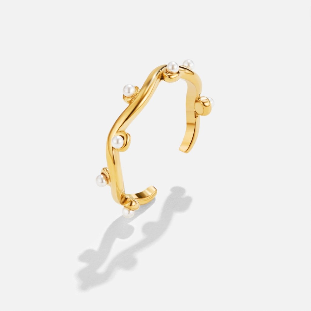 Wavey Pearl 18K Gold Ring, gold open cuff with a wavy band and small pearls, on a plain background