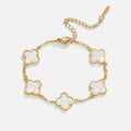 White Clover Bracelet, flat lay of gold bracelet with five white clover motifs