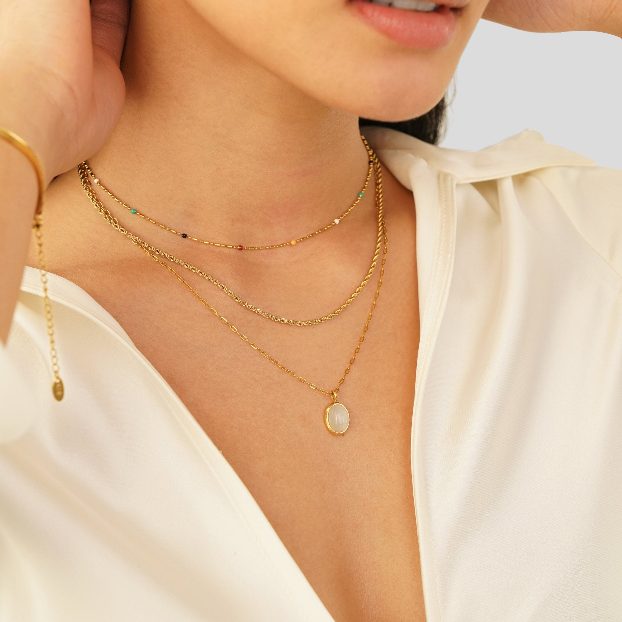 White Opal Necklace, worn layered at the neck over a cream blouse, with a pale oval pendant